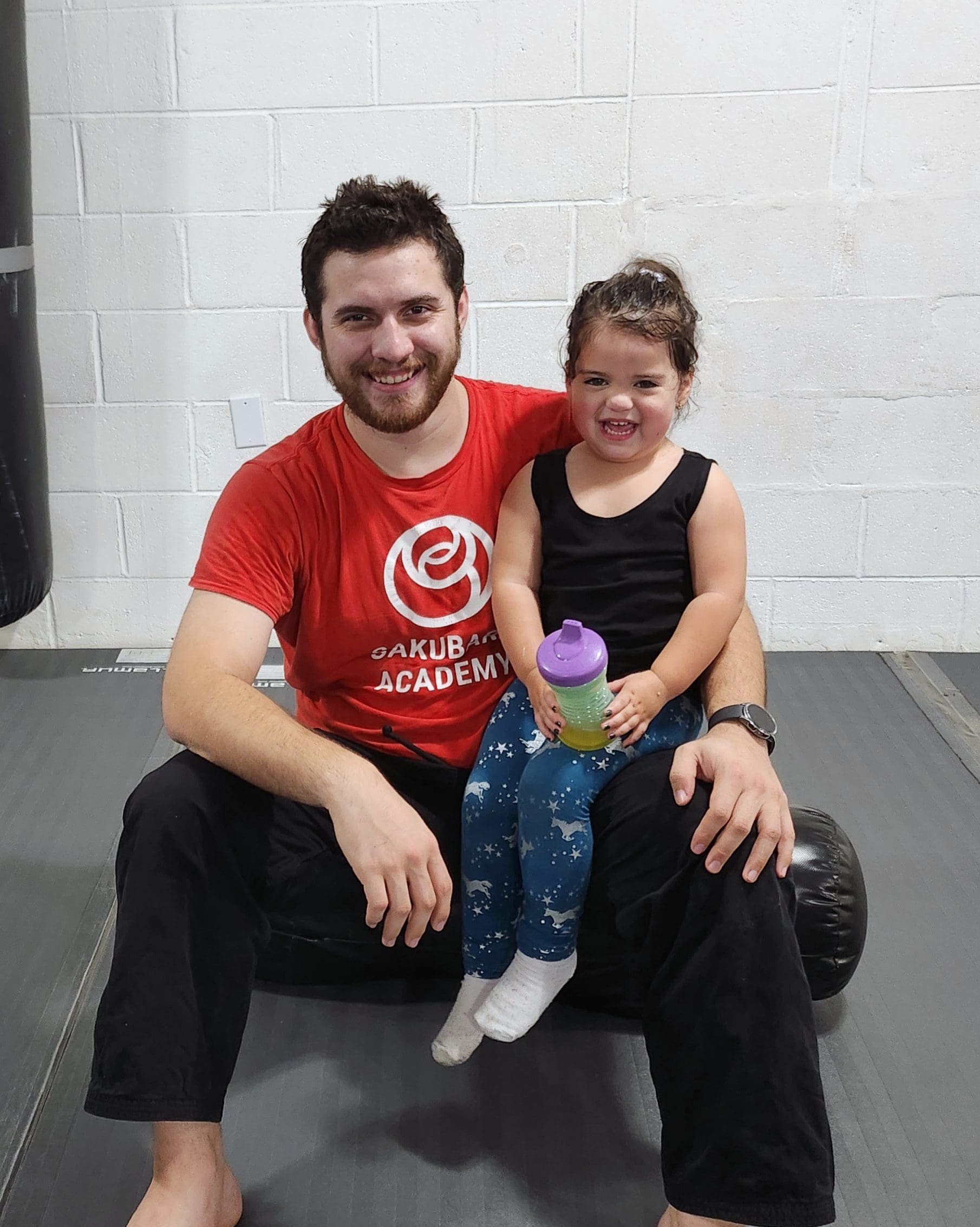A toddler sitting with the head instructor.
